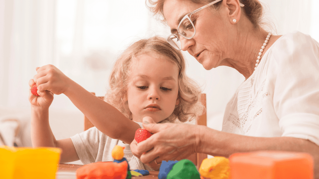 Nannytax | What does a nanny do? Nanny wearing glasses eating strawberries with a young child